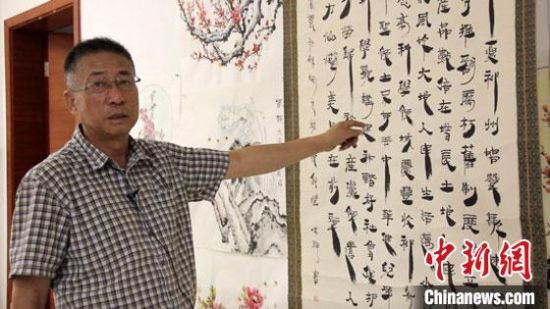 圖為朱群和他的敦煌漢簡(jiǎn)書(shū)體?！「攥?攝