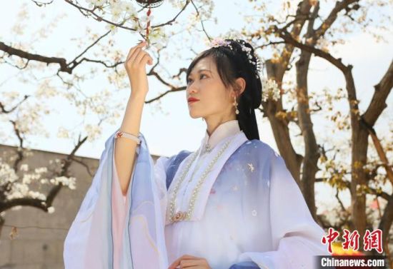 圖為蘭州青年身穿漢服在百年梨園賞景?！「哒?攝