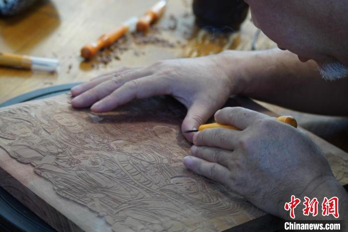 圖為徐晉林湊近木板，近距離制作雕版畫。　九美旦增 　攝
