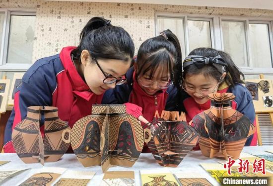 圖為學生用紙創(chuàng)作的立體彩陶?！⒂裉?攝