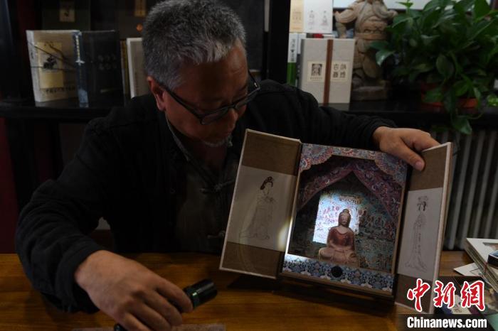 圖為讀者出版集團讀者晉林工作室獨立出品人徐晉林，展示互動性強的敦煌題材手工書。(資料圖) 楊艷敏 攝