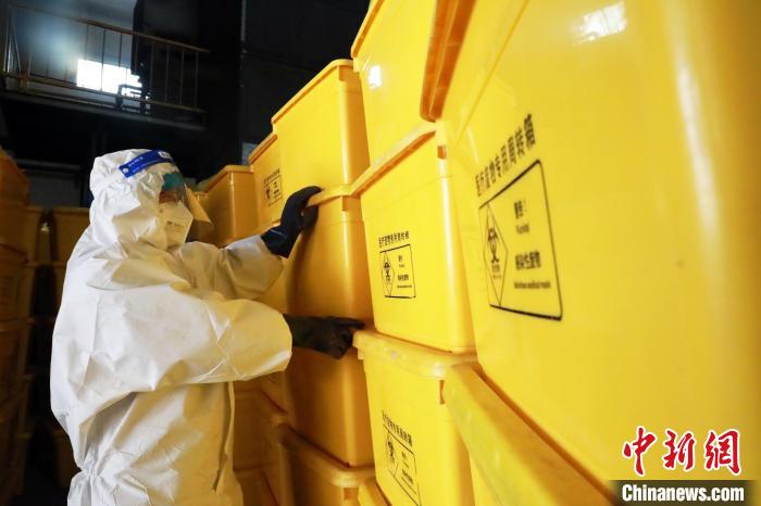 圖為工作人員搬運醫(yī)療廢物專用周轉(zhuǎn)箱。　魏建軍 攝