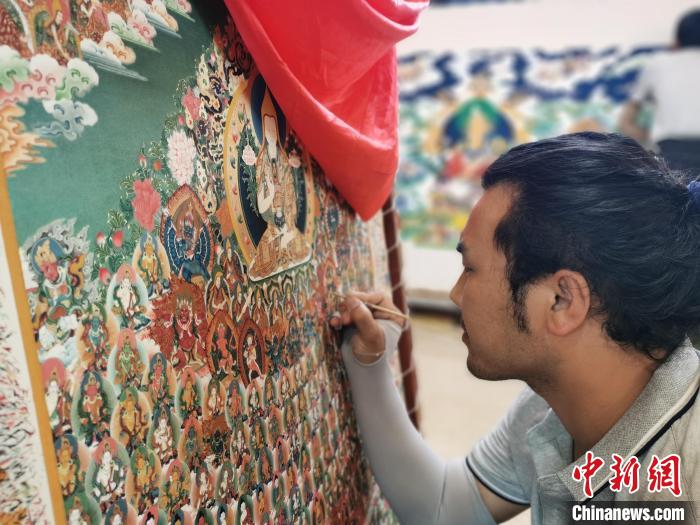 圖為更登才讓的徒弟繪畫唐卡。　張?zhí)砀?攝
