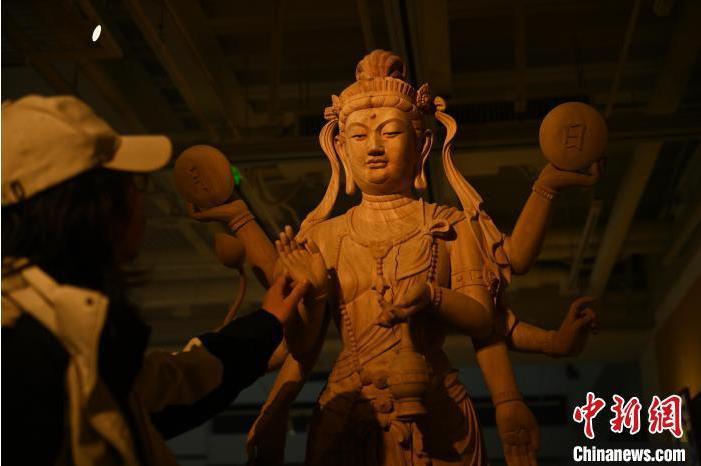 圖為季茂杰觀察自己創(chuàng)作的敦煌木雕。李亞龍 攝</p>
<p>