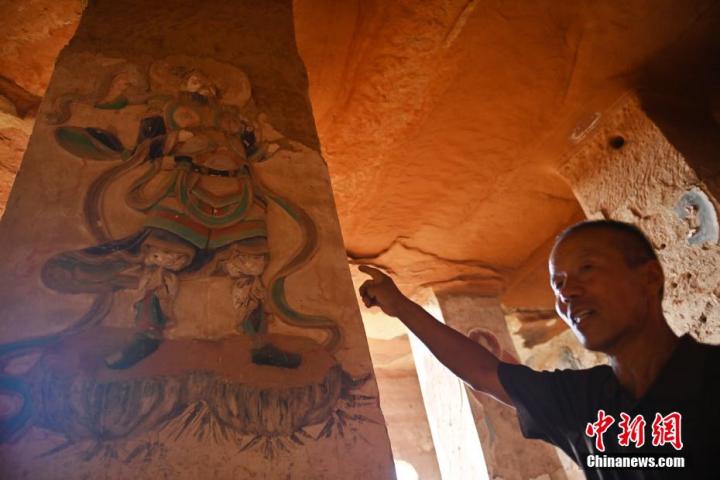 7月15日，甘肅省平?jīng)鍪袥艽h百里石窟長廊羅漢洞石窟內(nèi)，該窟文保員郭建平介紹窟內(nèi)石刻彩繪壁畫。郭建平家中三代人曾自發(fā)保護羅漢洞石窟。羅漢洞石窟遺存40余個窟龕，以北魏至清代風格為主。中新社記者 李亞龍 攝</p>
<p>