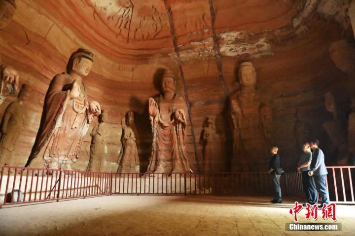 7月15日，游人參觀甘肅省平?jīng)鍪袥艽h百里石窟長廊中的南石窟寺1號窟。百里石窟長廊位于涇川縣境內(nèi)，由512個石窟、5眼窟中石井組成，現(xiàn)存王母宮石窟、鳳凰山石窟、南石窟寺、丈八寺石窟、羅漢洞石窟、太山寺石窟等規(guī)模較大的石窟群，還有數(shù)量眾多的小石窟群。南石窟寺開鑿于北魏永平三年，其中1號窟屬于大型七佛窟，七佛高達6米。中新社記者 李亞龍 攝