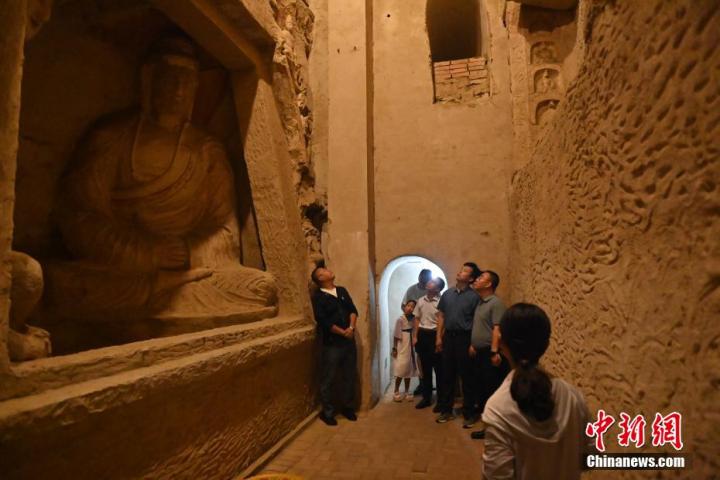 7月15日，游人參觀甘肅省平?jīng)鍪袥艽h百里石窟長廊中的王母宮石窟。百里石窟長廊位于涇川縣境內(nèi)，由512個石窟、5眼窟中石井組成，現(xiàn)存王母宮石窟、鳳凰山石窟、南石窟寺、丈八寺石窟、羅漢洞石窟、太山寺石窟等規(guī)模較大的石窟群，還有數(shù)量眾多的小石窟群。王母宮石窟又名千佛洞，該窟設(shè)計宏大，造像生動，窟內(nèi)擁有造像數(shù)百尊，是較為珍貴的佛教文化歷史遺存。中新社記者 李亞龍 攝</p>
<p>