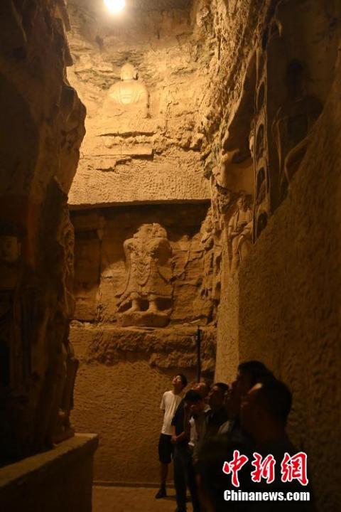 7月15日，游人參觀甘肅省平?jīng)鍪袥艽h百里石窟長廊中的王母宮石窟。百里石窟長廊位于涇川縣境內(nèi)，由512個石窟、5眼窟中石井組成，現(xiàn)存王母宮石窟、鳳凰山石窟、南石窟寺、丈八寺石窟、羅漢洞石窟、太山寺石窟等規(guī)模較大的石窟群，還有數(shù)量眾多的小石窟群。王母宮石窟又名千佛洞，該窟設(shè)計宏大，造像生動，窟內(nèi)擁有造像數(shù)百尊，是較為珍貴的佛教文化遺存。中新社記者 李亞龍 攝</p>
<p>
